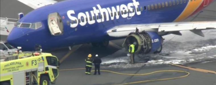 a blue airplane with white text and yellow fire trucks