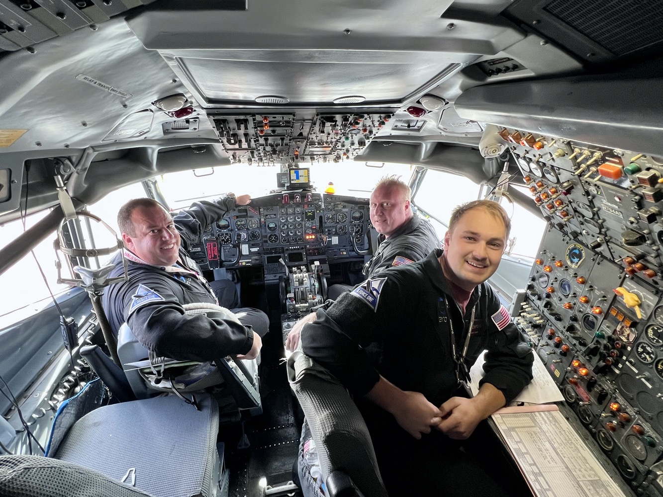 a group of men in a cockpit of a plane