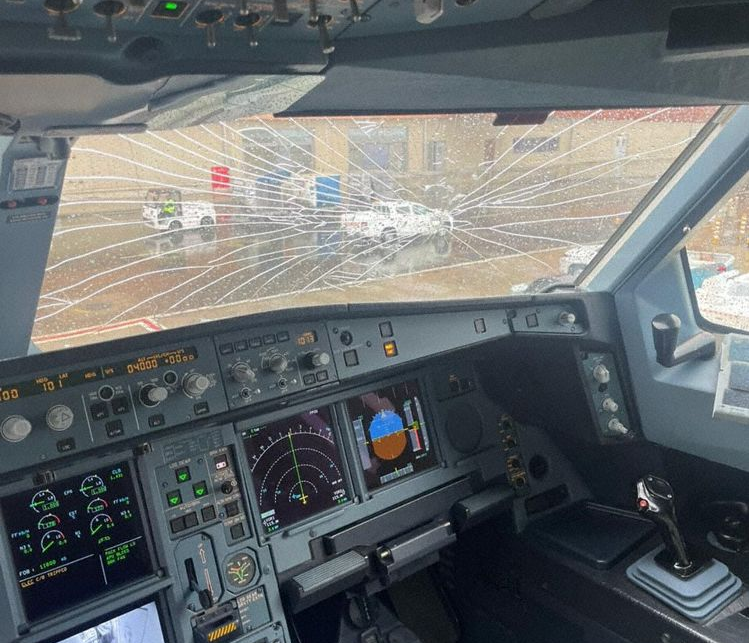 a cockpit of a plane with a broken window