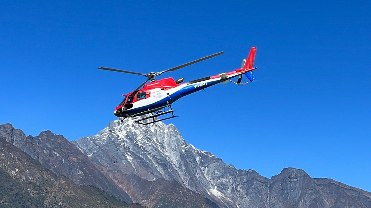 a helicopter flying over a mountain