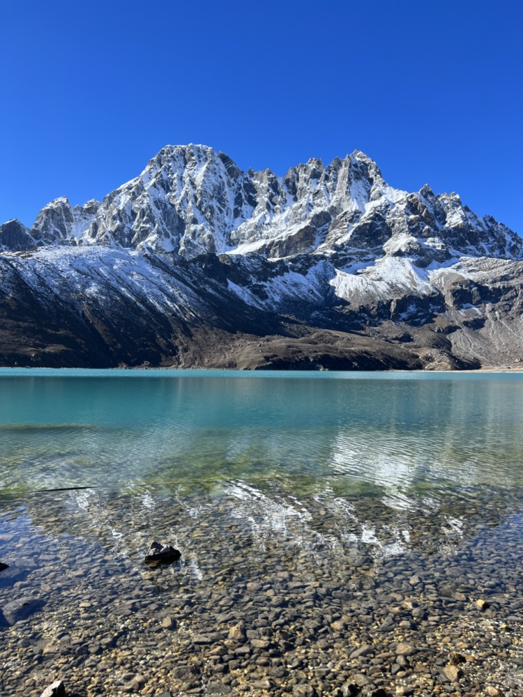 a mountain with snow on the top of a lake