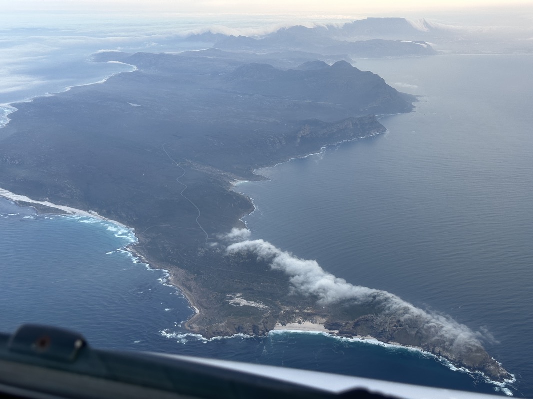 an aerial view of a land with water and clouds