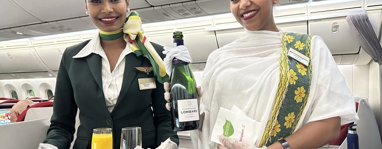 two women holding a tray and a bottle of wine