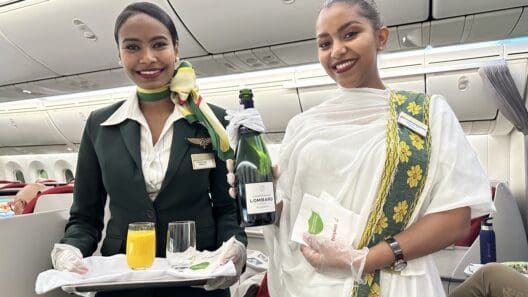 two women holding a tray and a bottle of wine