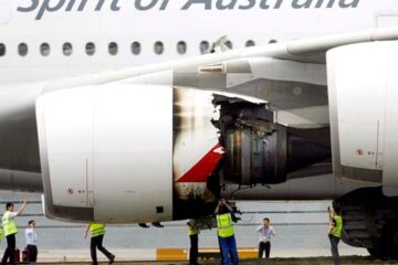 a group of people standing next to an airplane engine