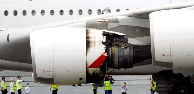 a group of people standing next to an airplane engine