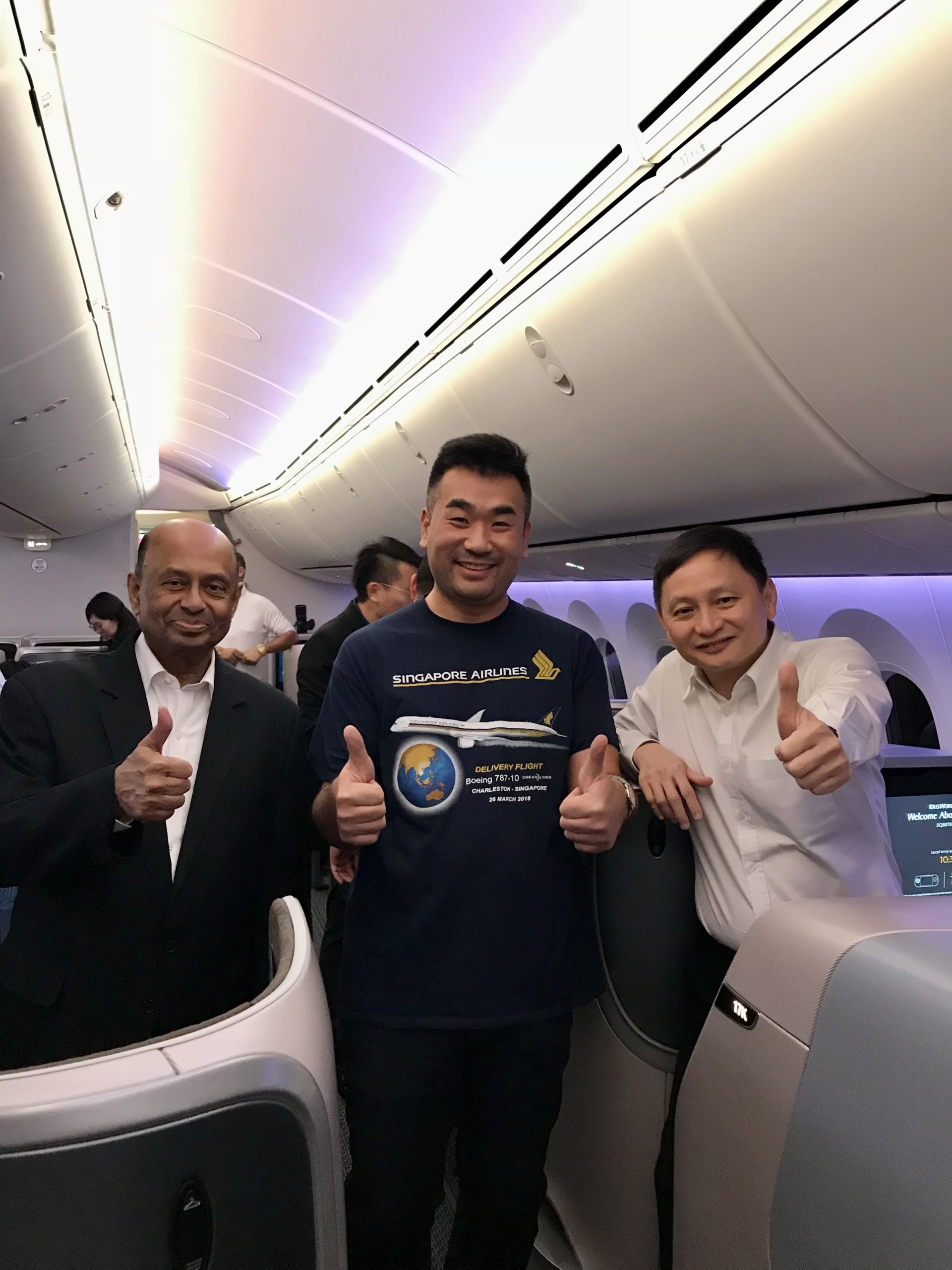 a group of men standing in an airplane with thumbs up