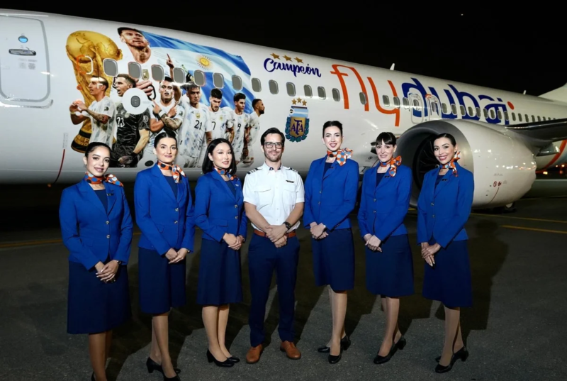 a group of people in blue uniforms standing in front of a plane