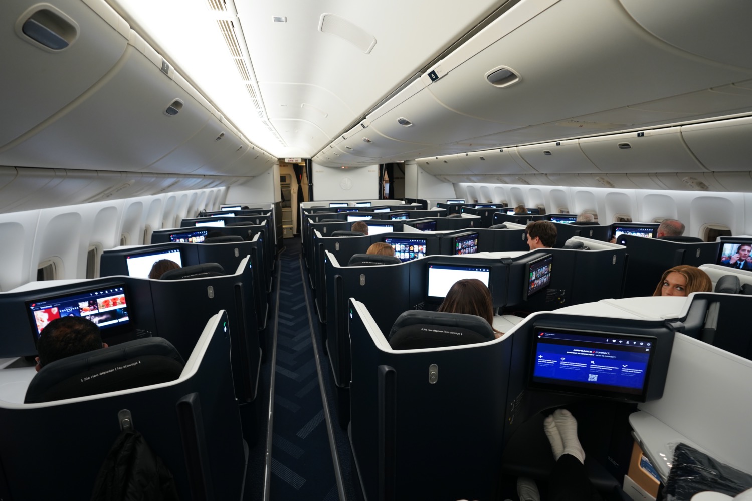 people sitting in an airplane with computers