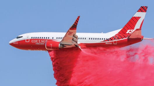 a plane with a red cloud of smoke