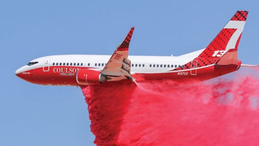 a plane with a red cloud of smoke