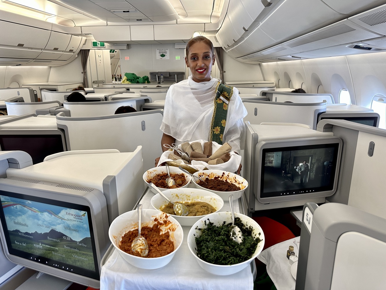 a woman standing in a plane with food on a table