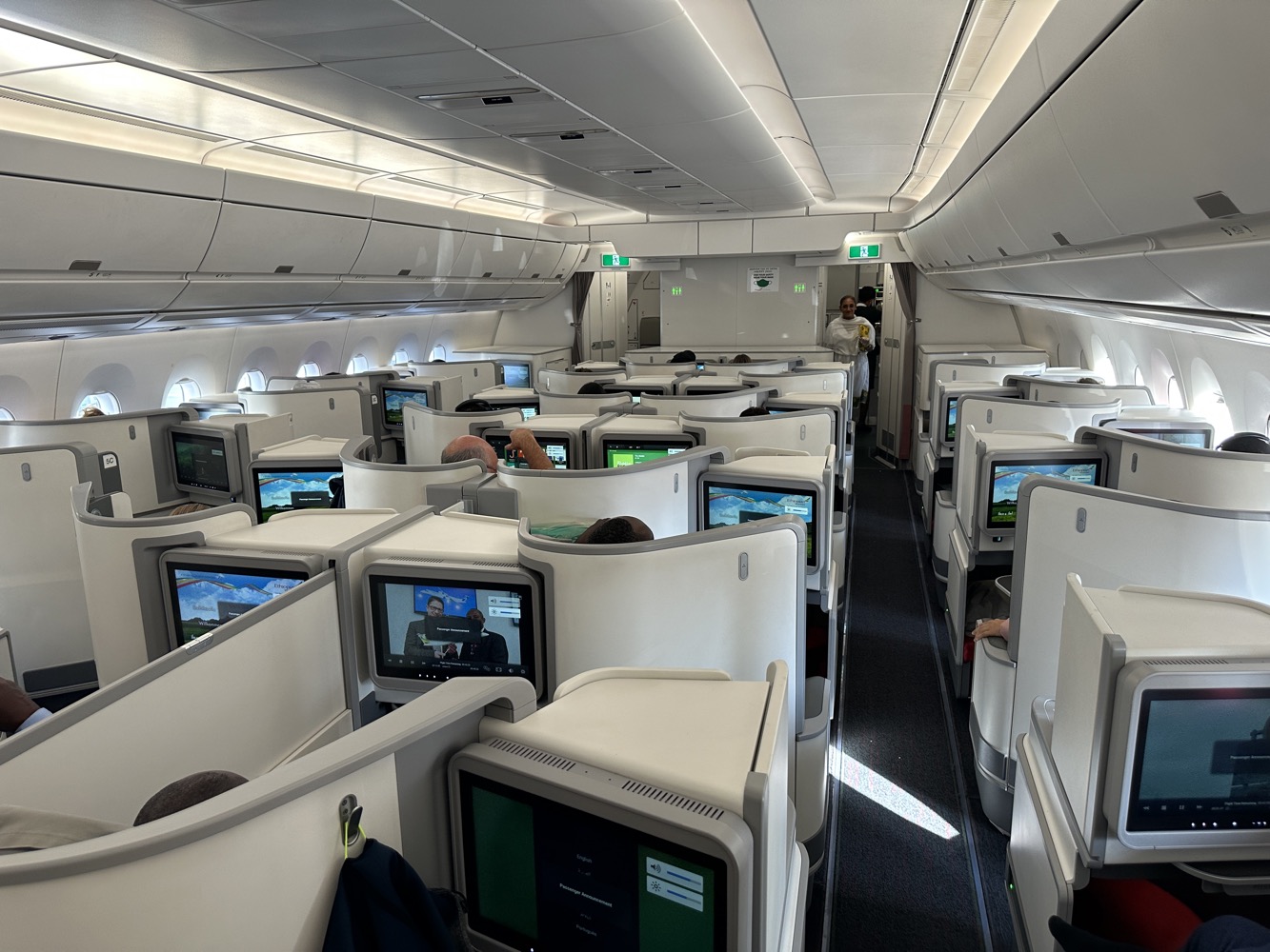 a group of people sitting in an airplane with monitors