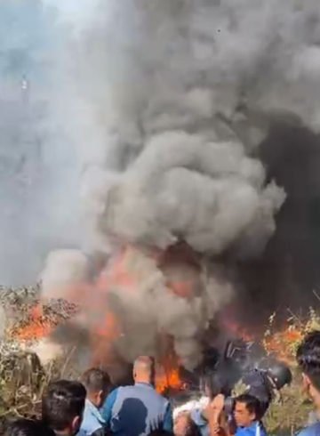 a group of people watching a burning car