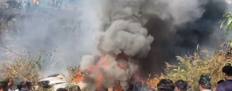 a group of people watching a burning car