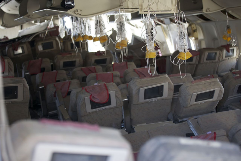 an inside of an airplane with seats and a few monitors