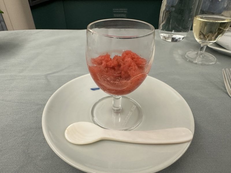 a glass of red liquid on a plate