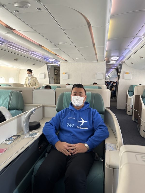 a man wearing a mask sitting in a chair in an airplane