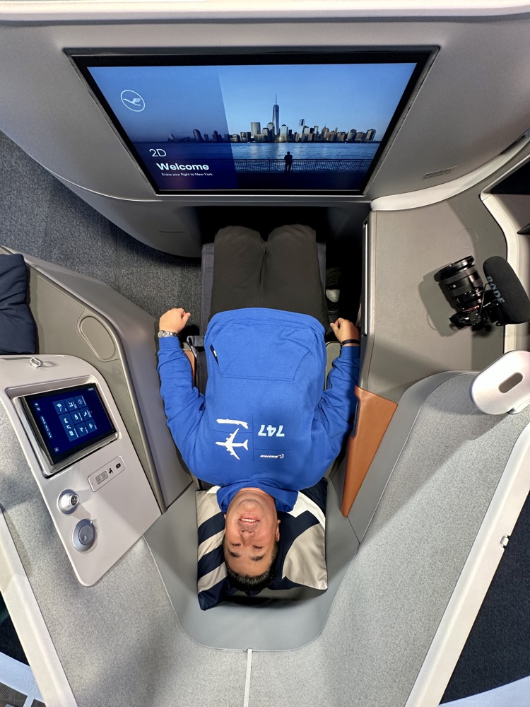 a man lying on a seat in a plane