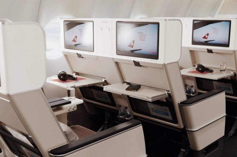 a row of monitors on the seats of an airplane