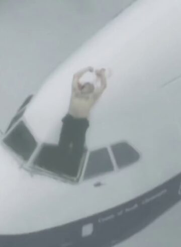 a man standing on the cockpit of an airplane