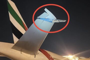 a plane tail fin with a plane in the background