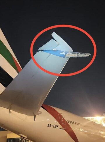 a plane tail fin with a plane in the background