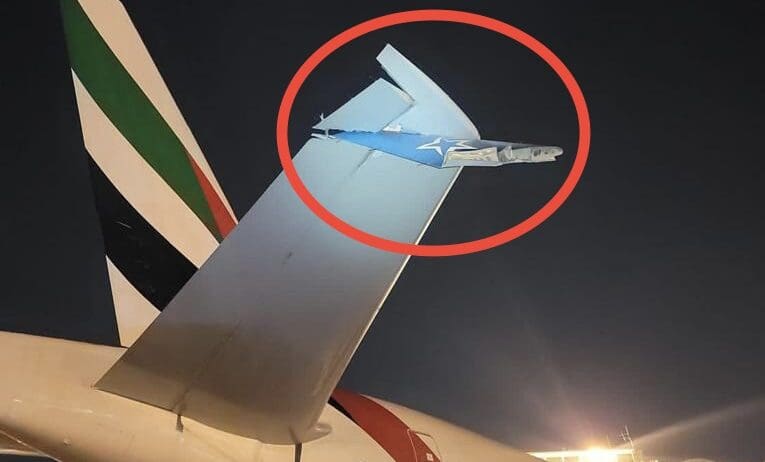 a plane tail fin with a plane in the background