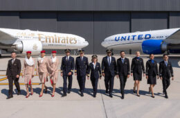 a group of people in uniform standing in front of airplanes