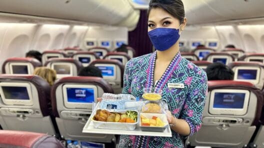 a woman wearing a face mask holding a tray of food