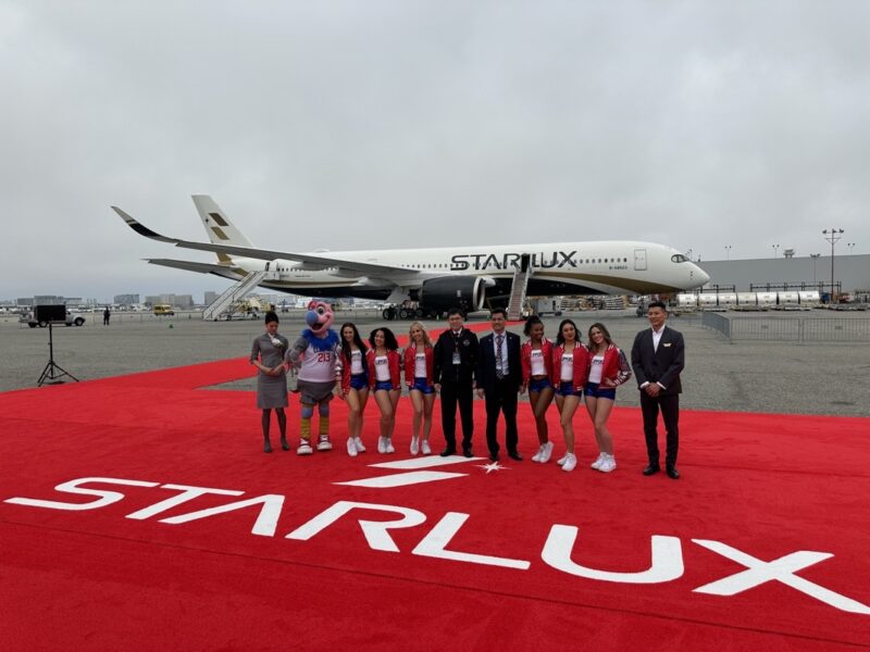 a group of people standing in front of a plane