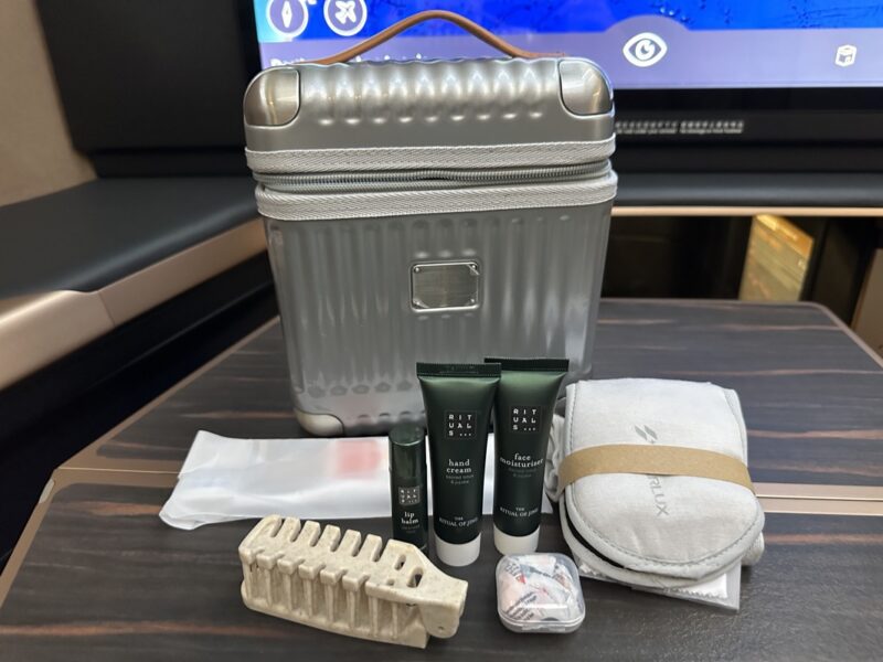 a silver suitcase with a few items on a table