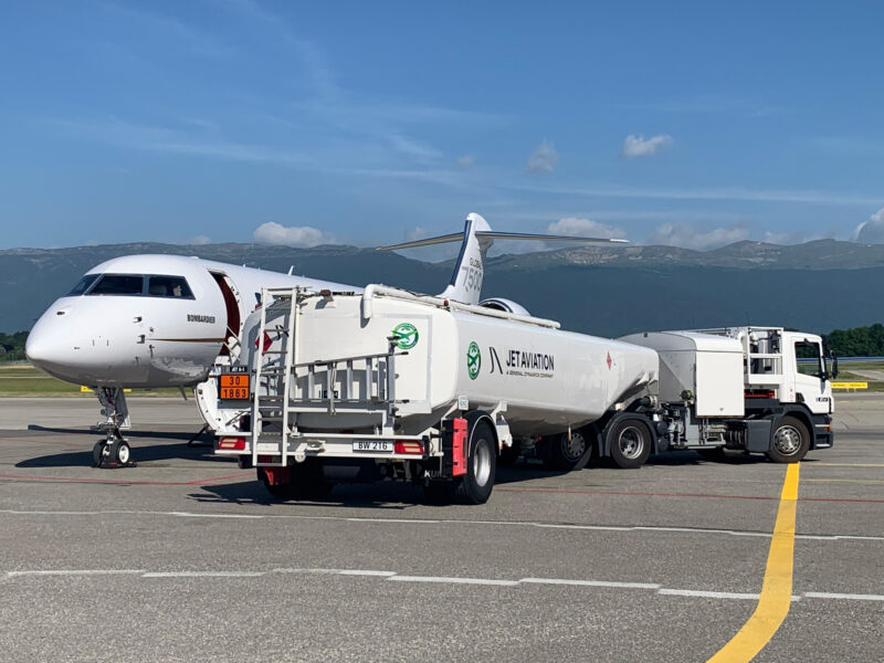 a white airplane and a tanker truck