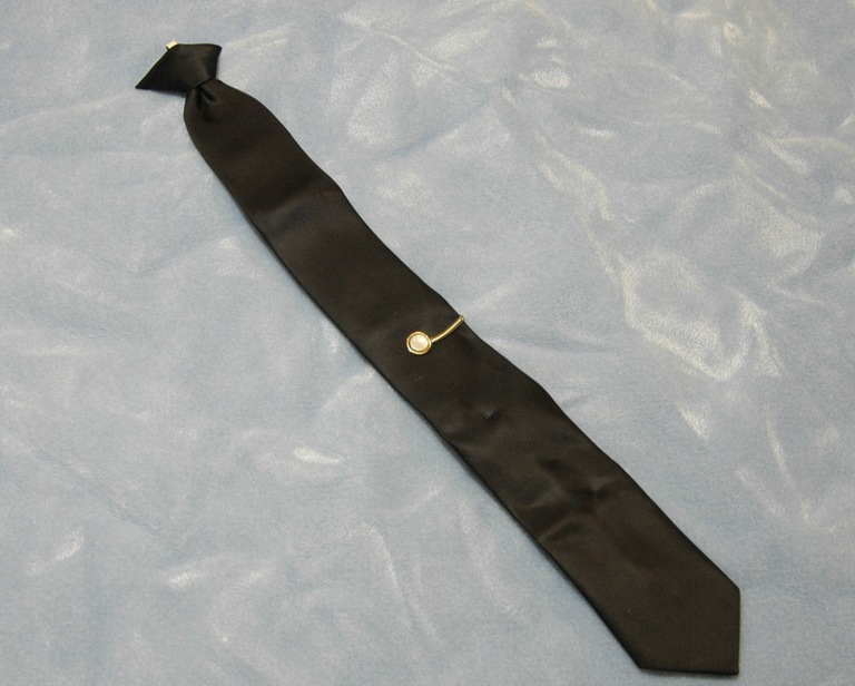 a black tie with a gold button