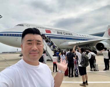 a man taking a selfie with a plane in the background