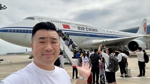 a man taking a selfie with a plane in the background