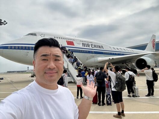 a man taking a selfie with a plane in the background