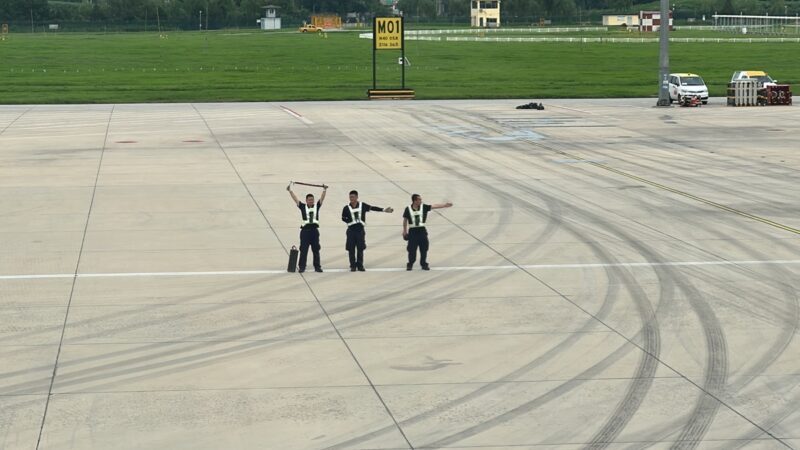 a group of men standing on a runway