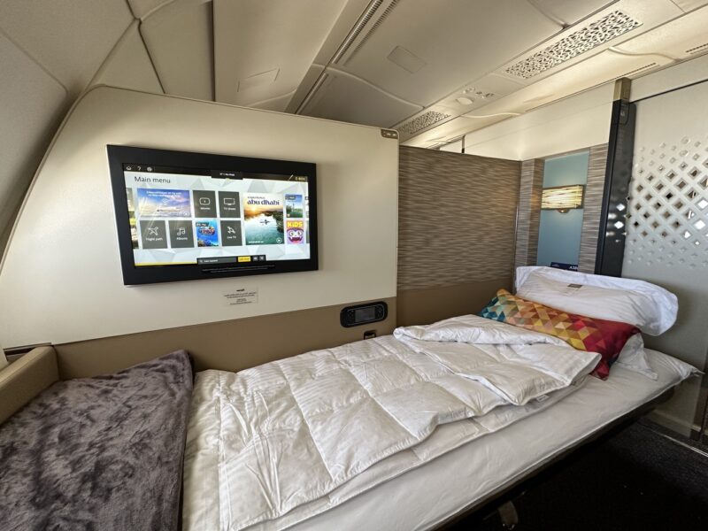 a bed with a tv on the wall