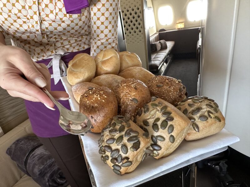 a person holding a tray of bread