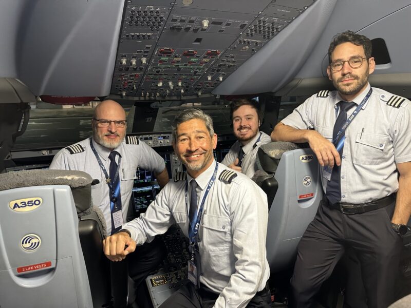 a group of men in uniform sitting in an airplane cockpit