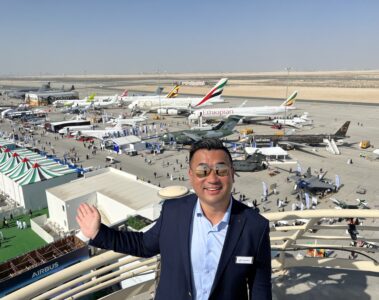 a man standing on a balcony with planes in the background