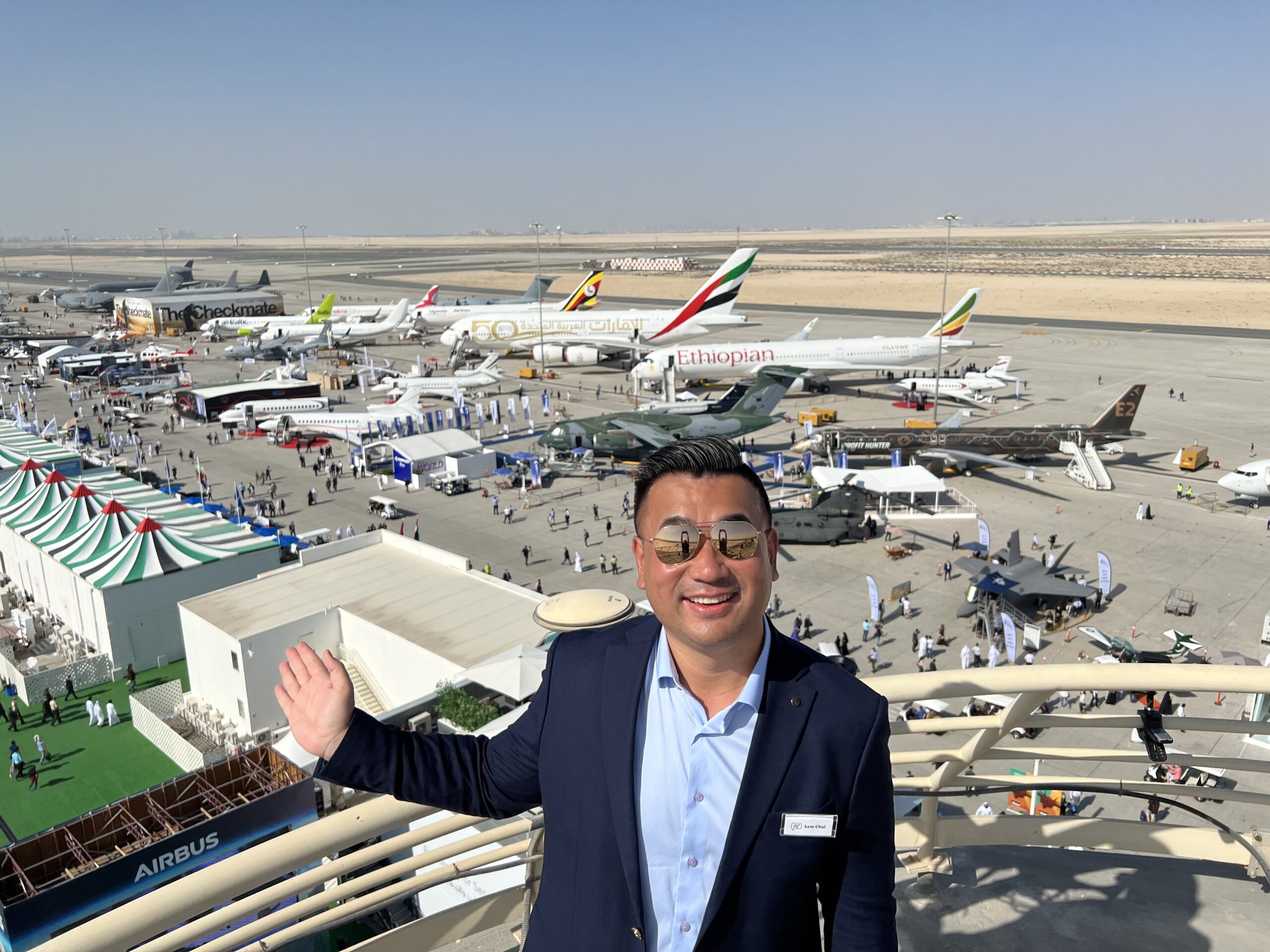 a man standing on a balcony with planes in the background