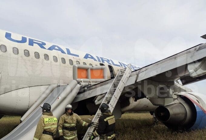 a group of people in fire suits standing next to an airplane