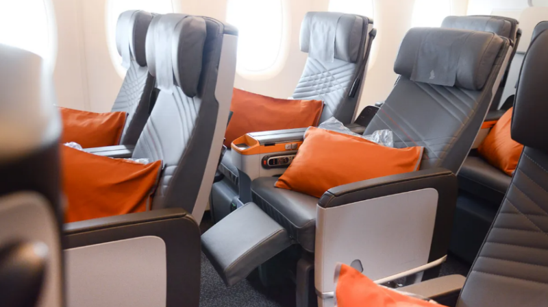 a row of seats with orange pillows