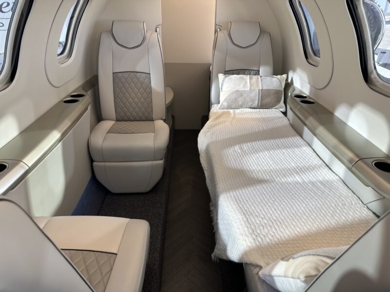 a bed and chairs in an airplane