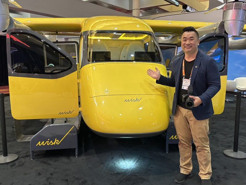 a man standing next to a yellow helicopter