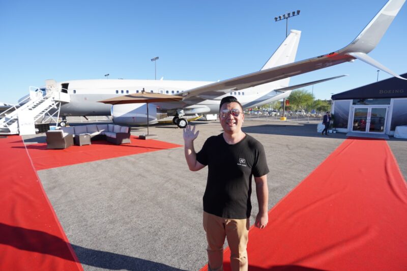 a man waving in front of an airplane