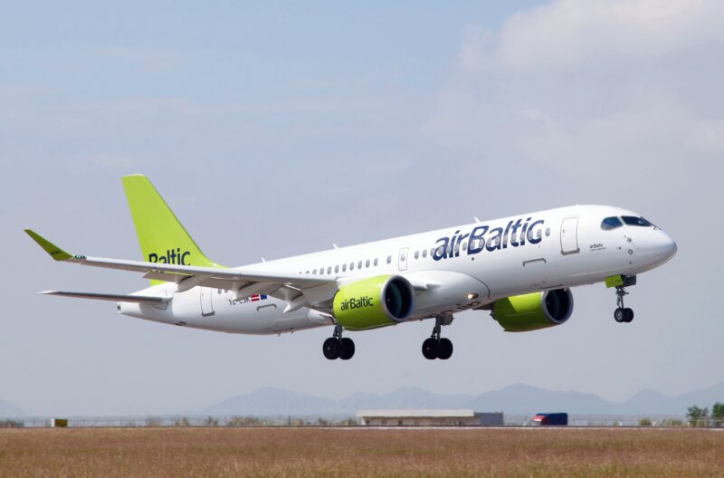 a white and green airplane taking off