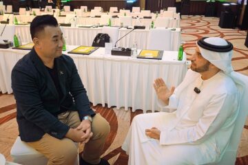 a man sitting in a chair with a man in a white robe